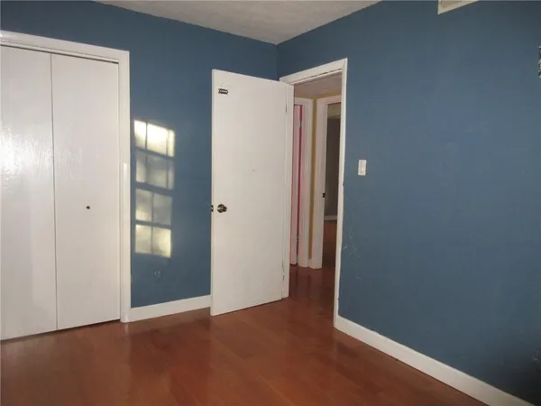 an empty room with closet and mirror