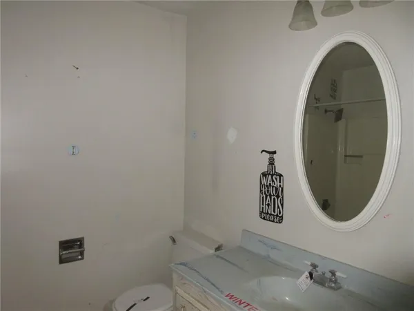 a bathroom with a toilet a sink and mirror