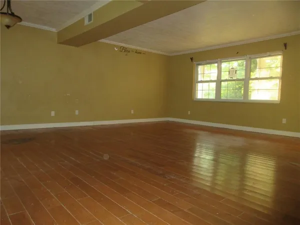 a view of room with window and wooden floor
