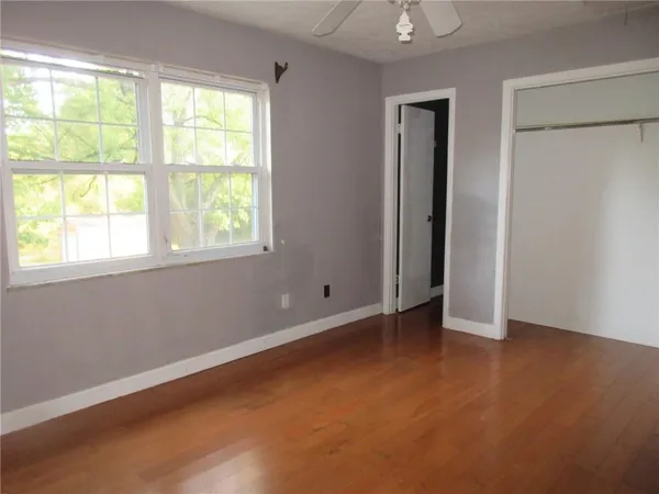 an empty room with windows and closet