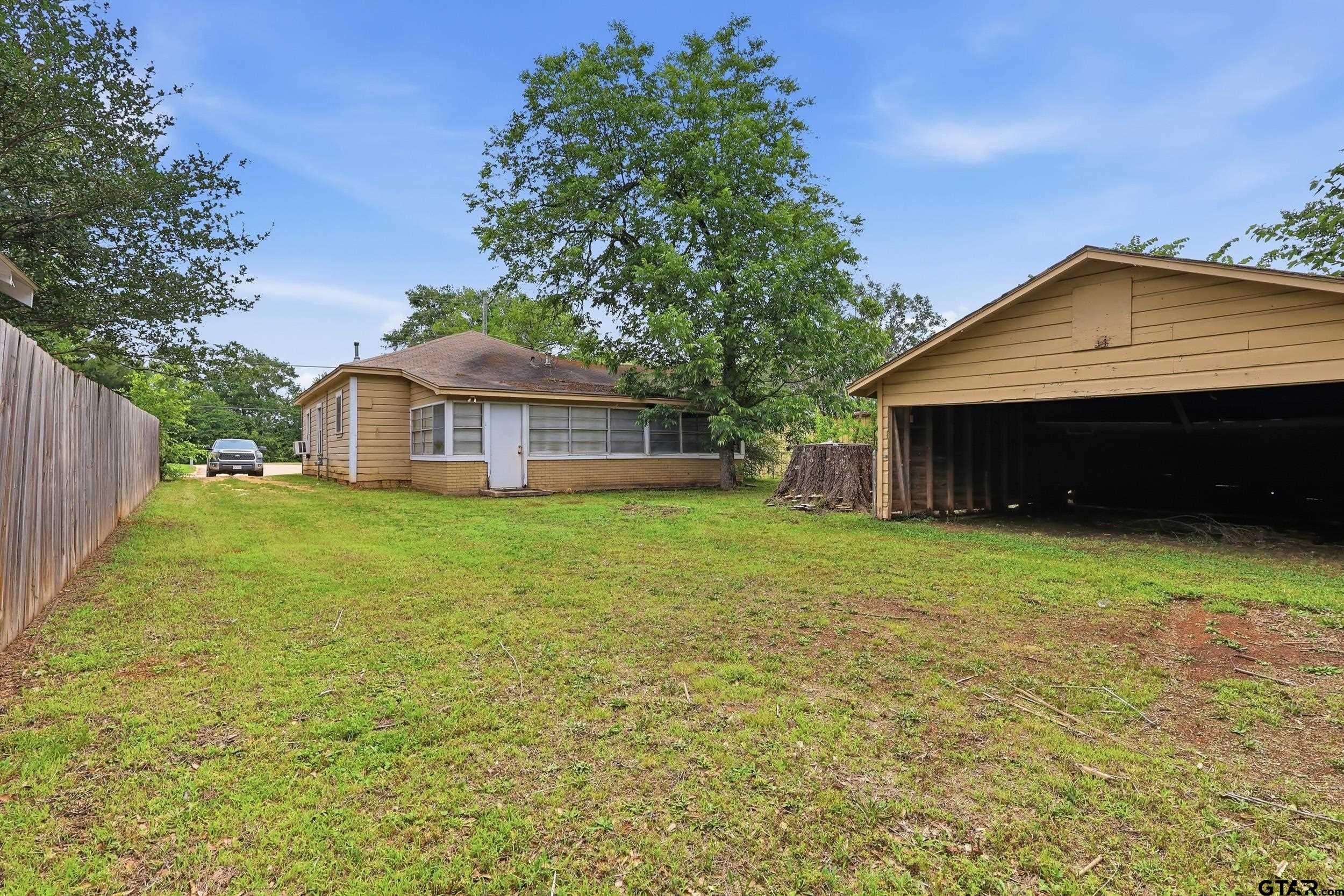 405 Rusk Street Pittsburg, TX 75686 - Photo 10 of 33 a front view of a house with a garden