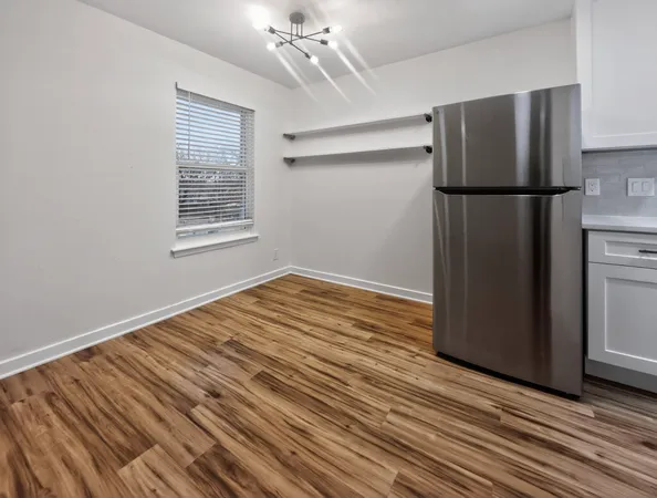 a view of empty room with wooden floor and window