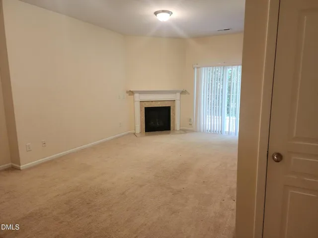 a view of empty room with a fireplace