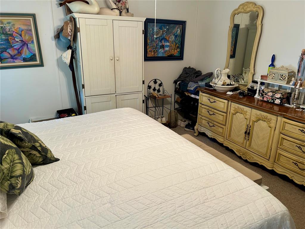 25646 Bass Road Astor, FL 32102 - Photo 13 of 48 a bedroom with a bed and a flat tv screen on the dresser