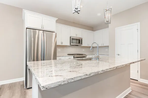 a kitchen with stainless steel appliances granite countertop a sink refrigerator and microwave