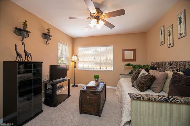 a living room with furniture a flat screen tv and a window