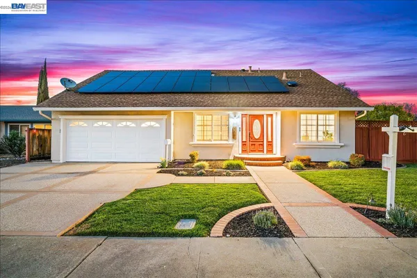 a view of yellow house with a yard in front of it