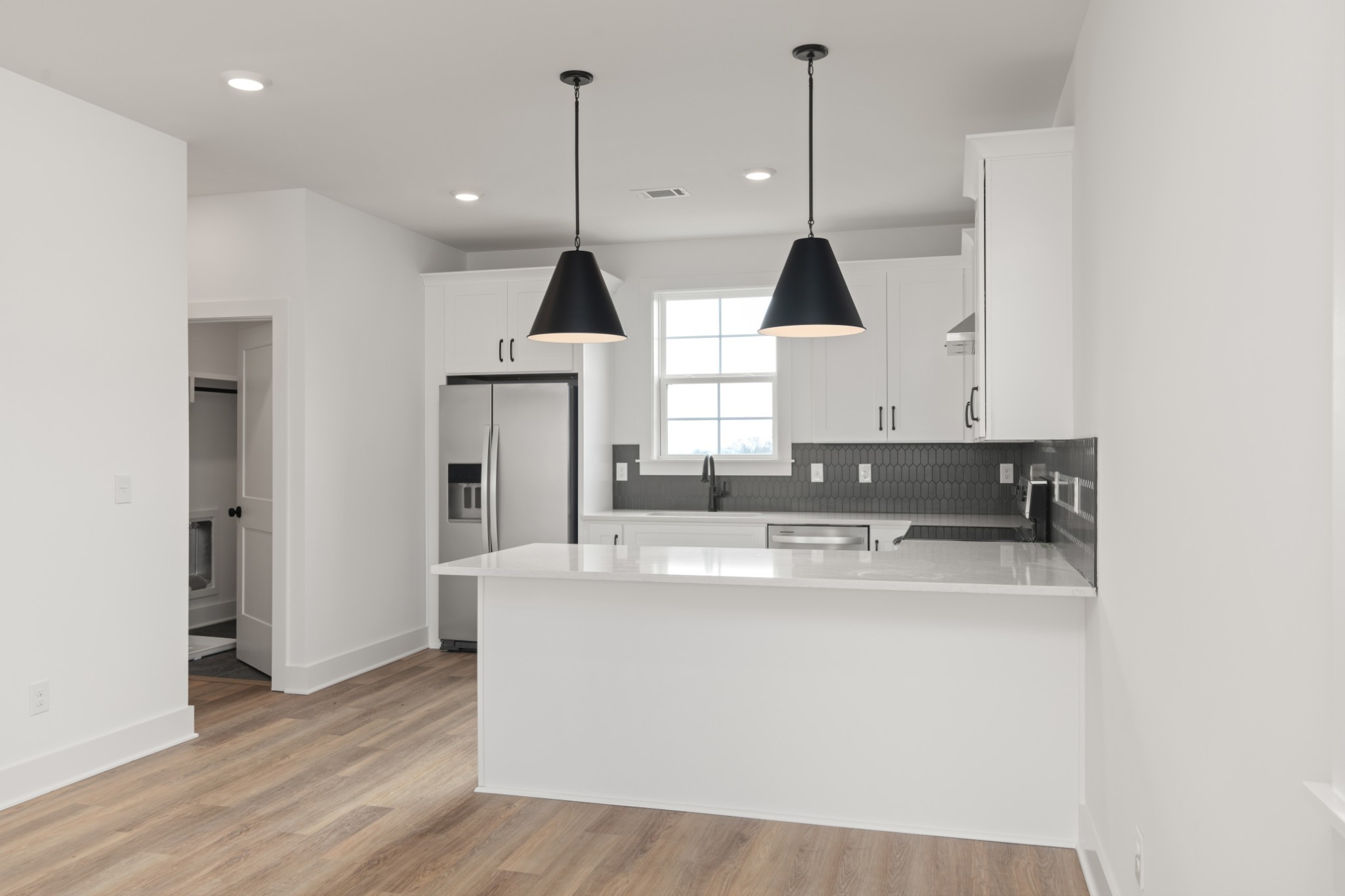 a view of a kitchen with stainless steel appliances granite countertop a sink a stove and a wooden floors