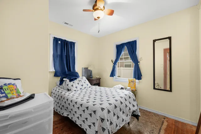 a bedroom with a bed and wooden floor