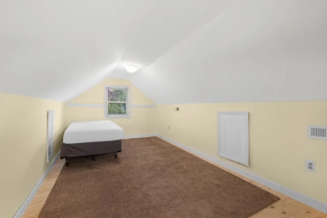 a spacious bedroom with a bed and cabinet