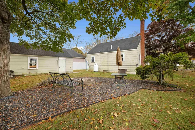 a backyard of a house with table and chairs