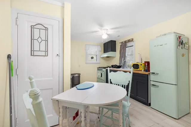 a kitchen with stainless steel appliances a refrigerator a sink a stove a dining table and chairs