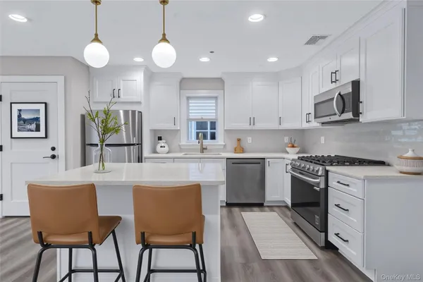 a kitchen with a stove cabinets and chairs