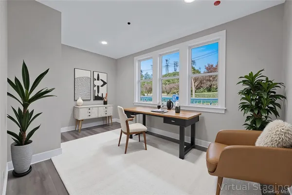 a living room with furniture a large window and a potted plant