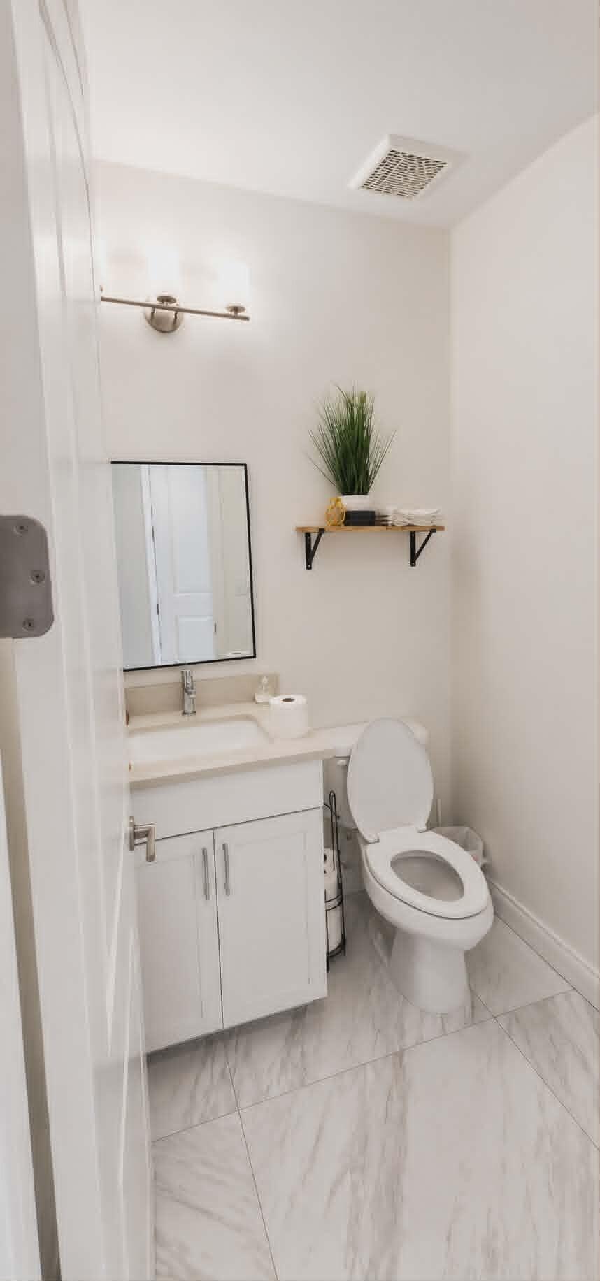 19179 Rolling Acrs Road Loxahatchee, FL 33470 - Photo 30 of 38 a bathroom with a toilet sink and mirror
