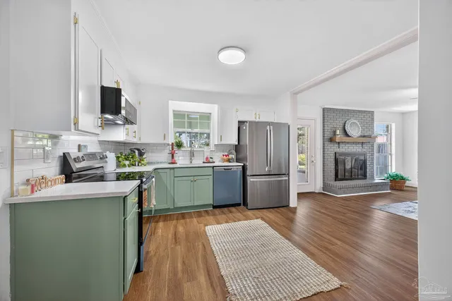 a kitchen with a refrigerator and a stove top oven