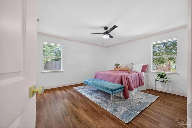 a bathroom with a toilet sink and mirror with window