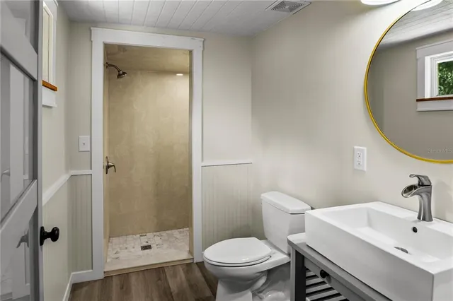 a view of a room with wooden floor and a bathroom