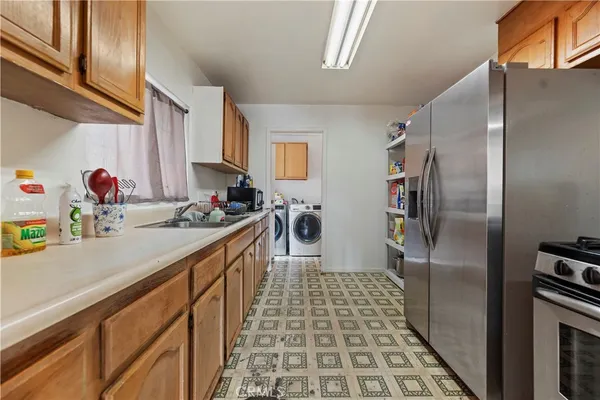 a kitchen with a sink a refrigerator and cabinets
