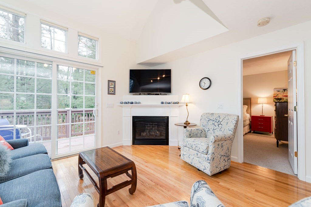 23 Gold Leaf Lane, Unit 23 Mashpee, MA 02649 - Photo 2 of 32 a living room with furniture a flat screen tv and a fireplace