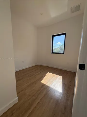 a view of a room with wooden floor and white walls