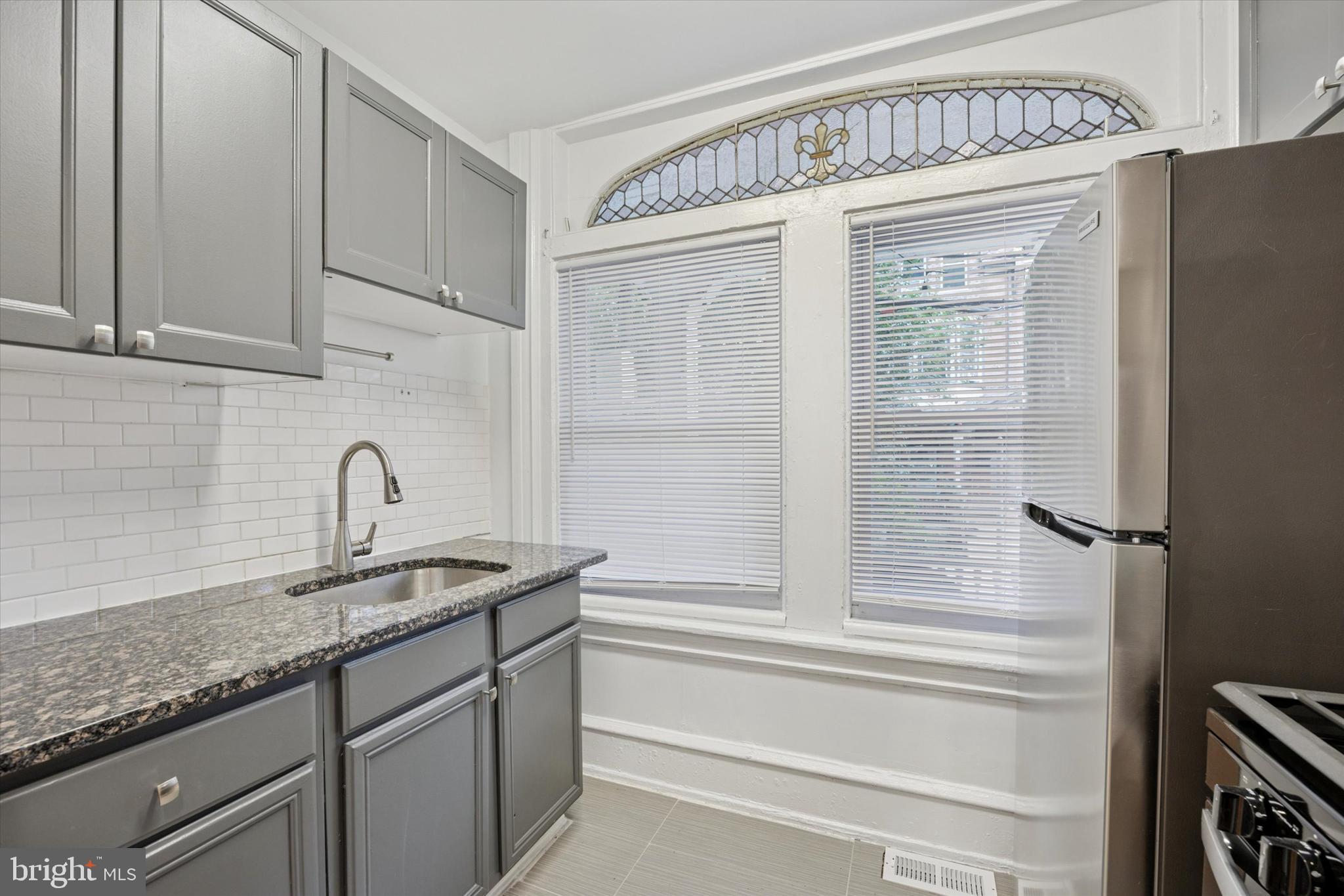 236 Buckingham Place Philadelphia, PA 19104 - Photo 2 of 11 a bathroom with a granite countertop sink and a mirror