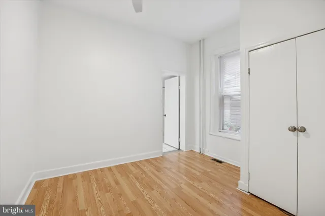 a view of a bedroom with wooden floor and closet