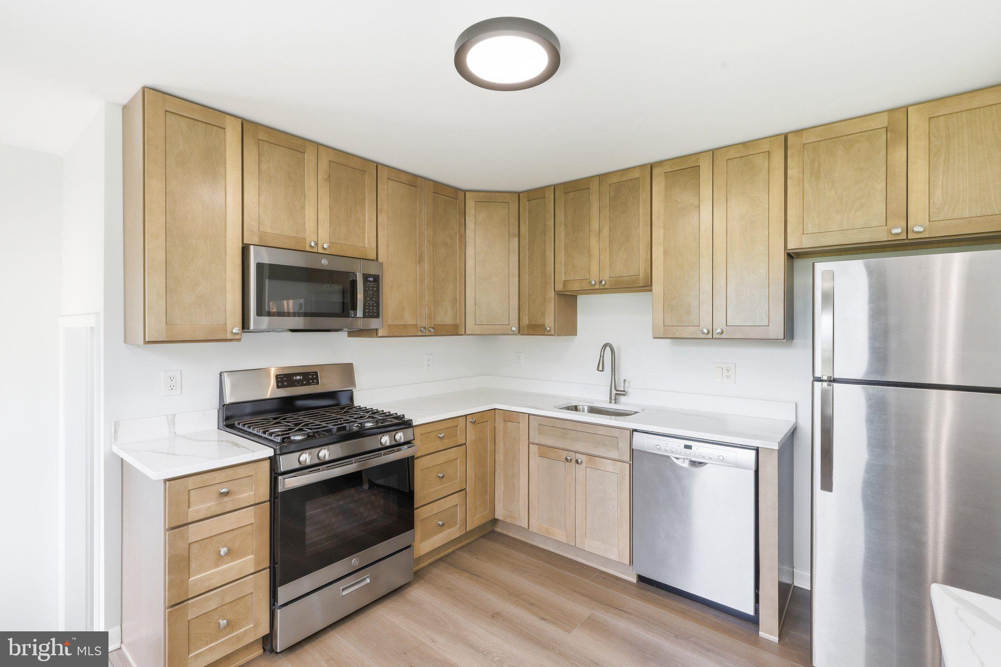 9005 Perring Park Road Baltimore, MD 21234 - Photo 8 of 20 a kitchen with a sink a stove and refrigerator