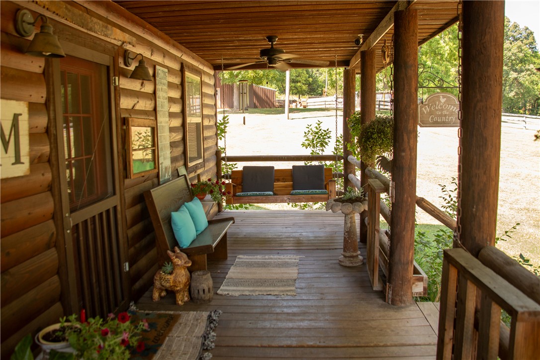 2026 Dry Creek Road St. Joe, AR 72675 - Photo 24 of 60 Expansive wood-finish porch with a swing, log-style columns, and a wood-slat ceiling with a ceiling fan