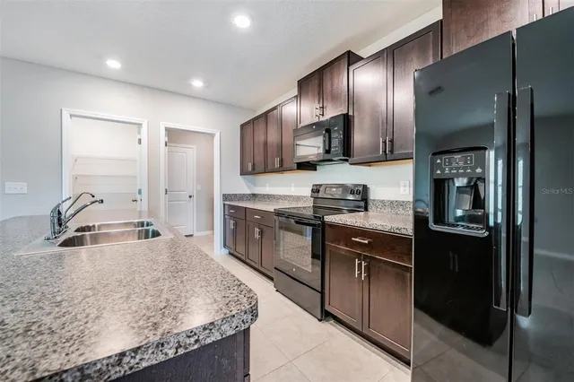 a kitchen with stainless steel appliances granite countertop a sink refrigerator and stove
