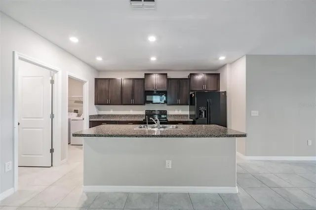a large kitchen with a counter top stainless steel appliances and cabinets