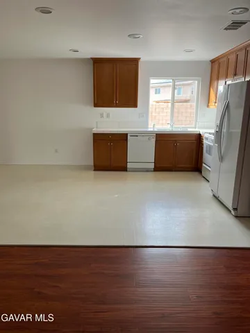 a kitchen with granite countertop a refrigerator and a sink