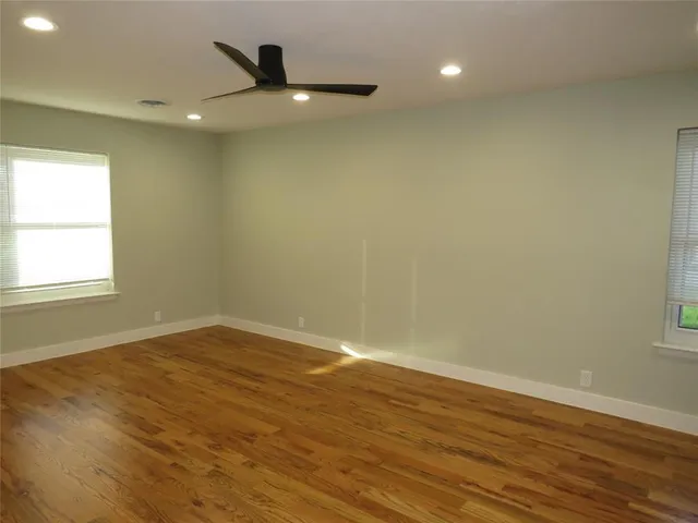 an empty room with wooden floor and bathroom
