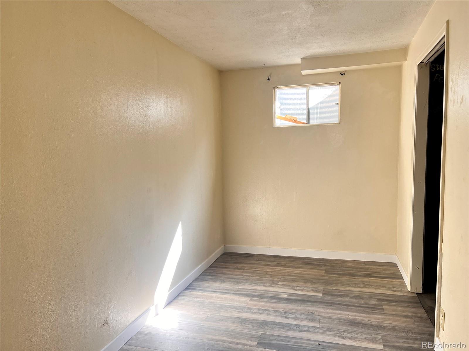 1711 Norfolk Street, Unit D Aurora, CO 80011 - Photo 11 of 16 a view of an empty room with wooden floor and a window