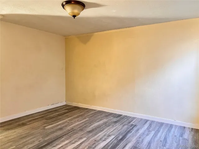 a view of a room with wooden floor and a ceiling fan