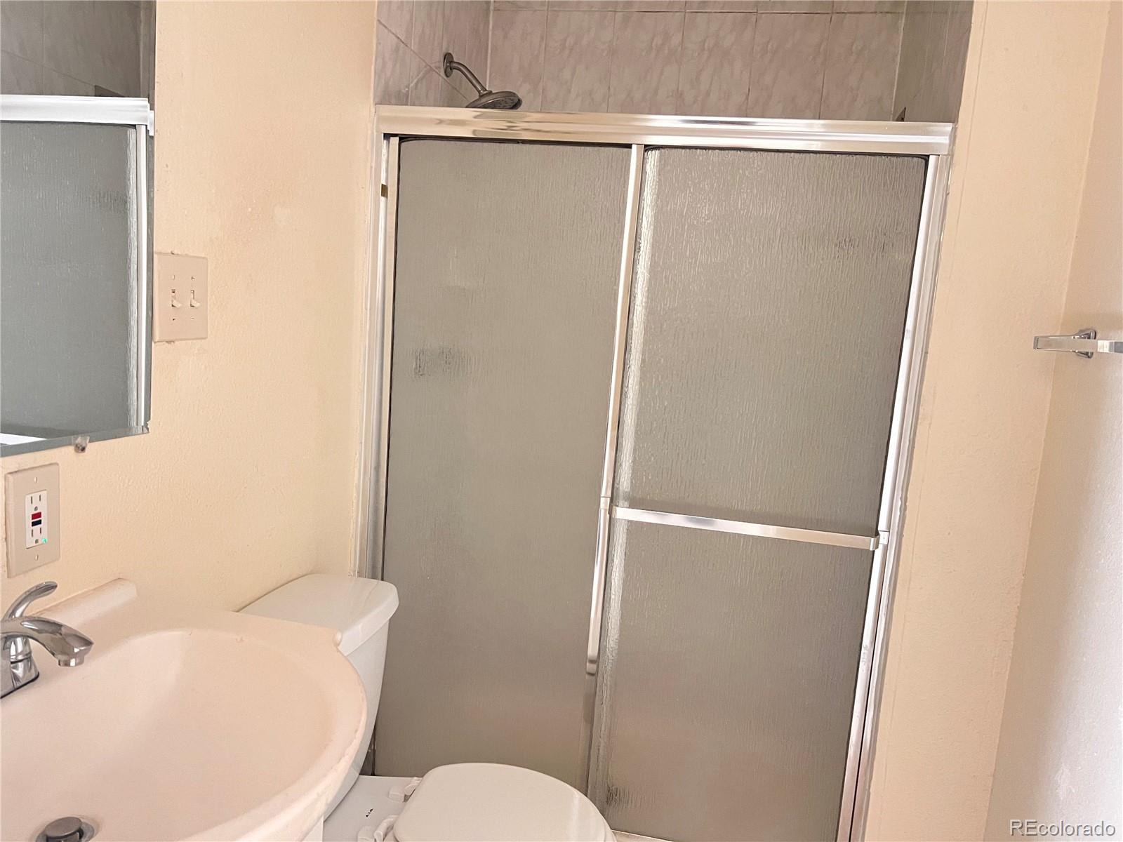 1711 Norfolk Street, Unit D Aurora, CO 80011 - Photo 13 of 16 a white toilet sitting next to a bathroom sink