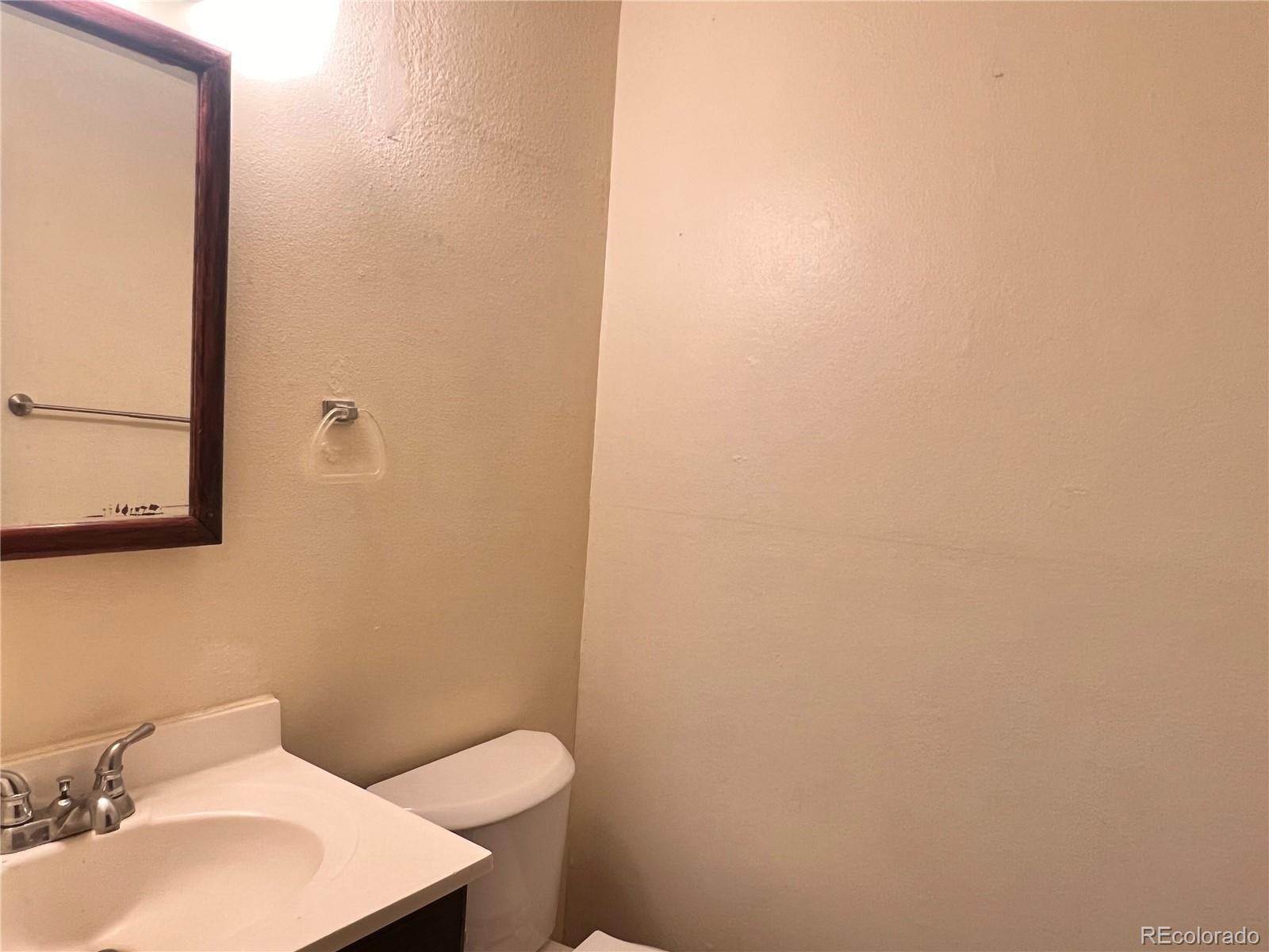 1711 Norfolk Street, Unit D Aurora, CO 80011 - Photo 14 of 16 a bathroom with a sink and a toilet