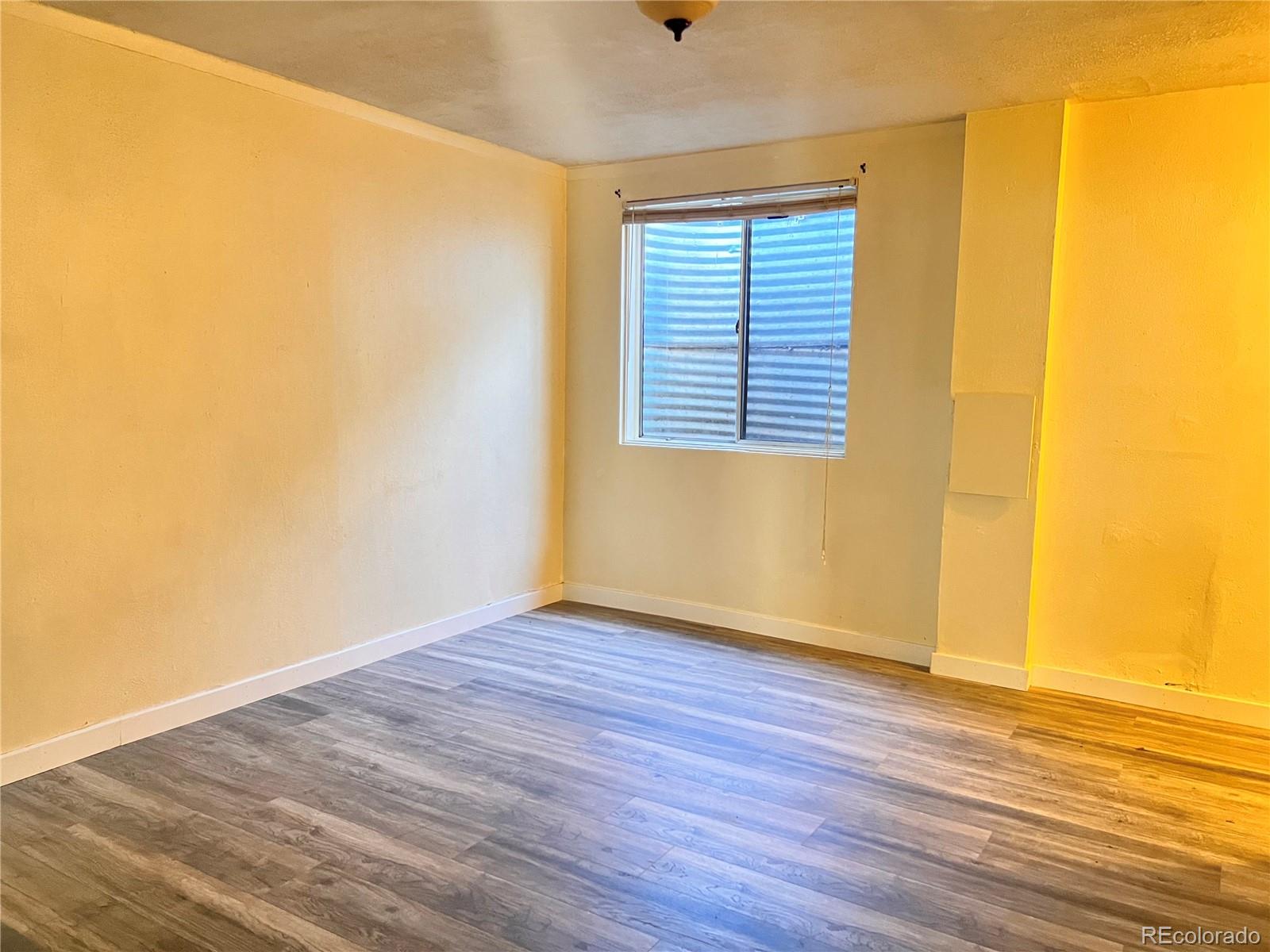 1711 Norfolk Street, Unit D Aurora, CO 80011 - Photo 15 of 16 a view of an empty room with wooden floor and a window