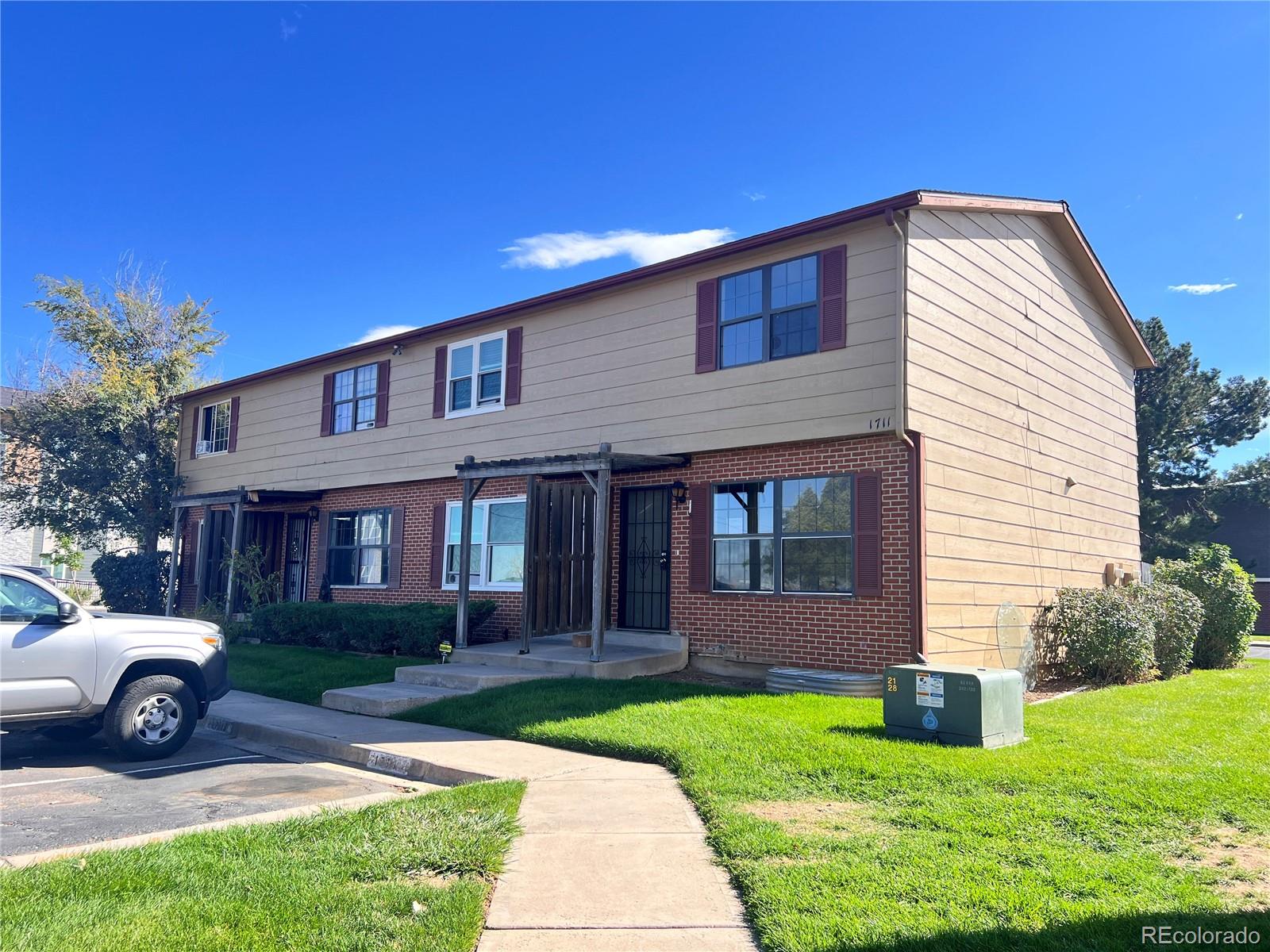 1711 Norfolk Street, Unit D Aurora, CO 80011 - Photo 2 of 16 a view of a house with a yard and plants