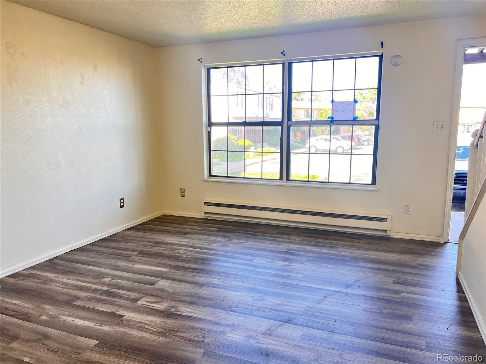 1711 Norfolk Street, Unit D Aurora, CO 80011 - Photo 4 of 16 an empty room with wooden floor and windows