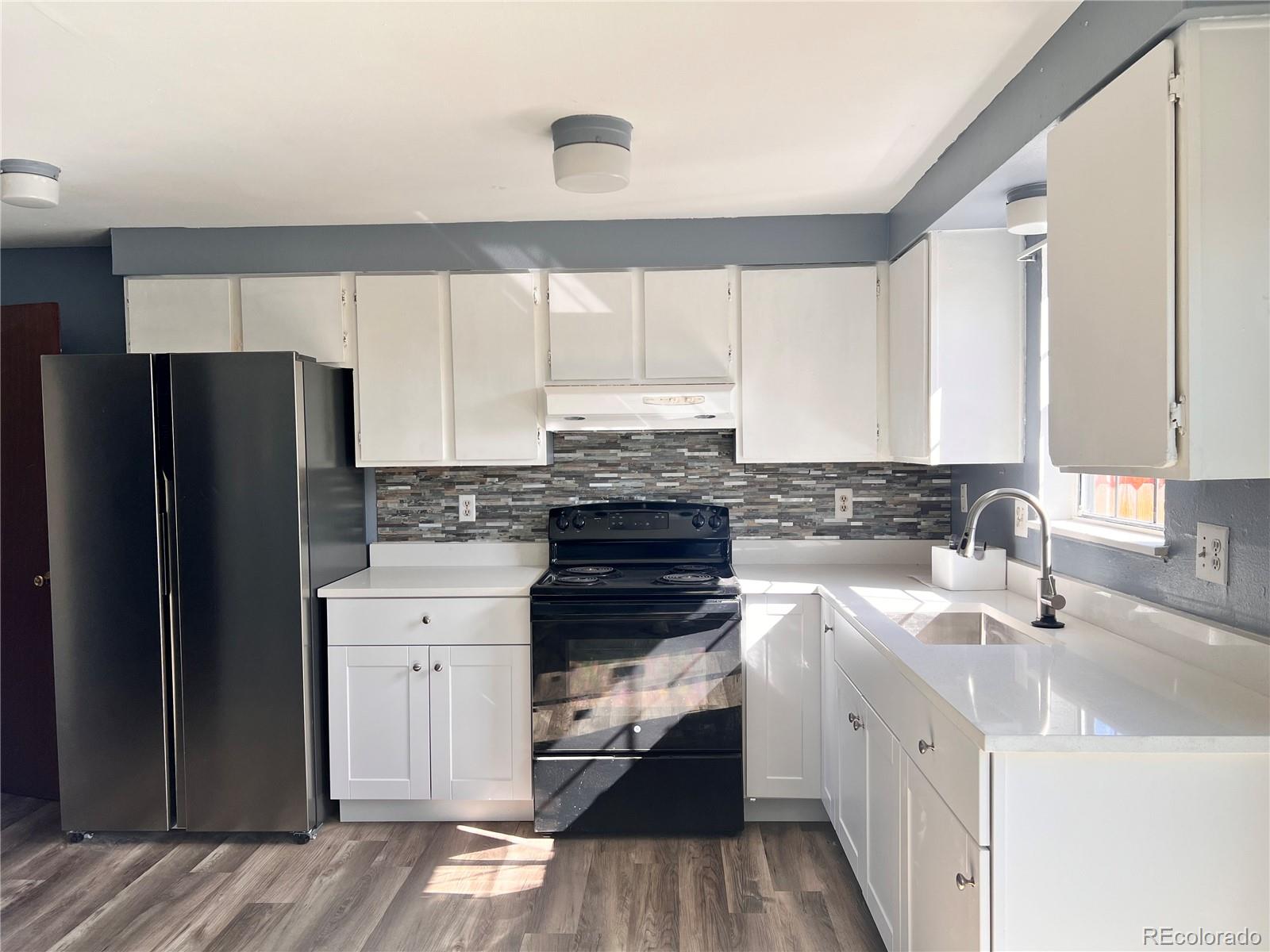 1711 Norfolk Street, Unit D Aurora, CO 80011 - Photo 7 of 16 a kitchen with a refrigerator sink and cabinets