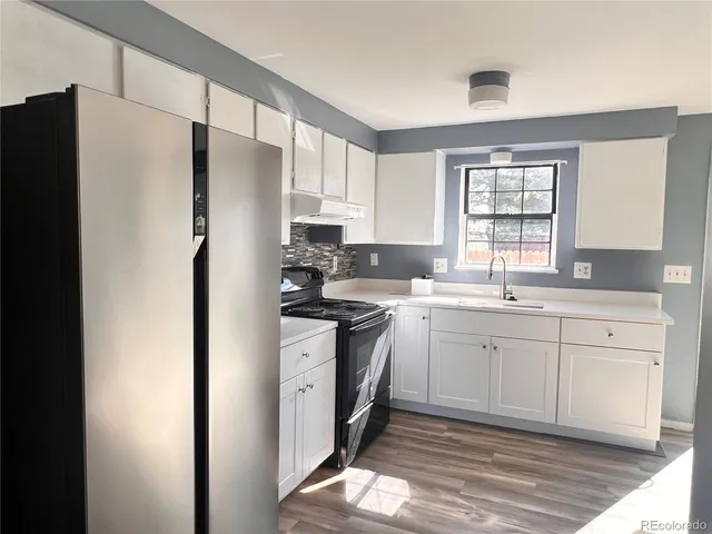 a kitchen with stainless steel appliances a refrigerator sink and cabinets