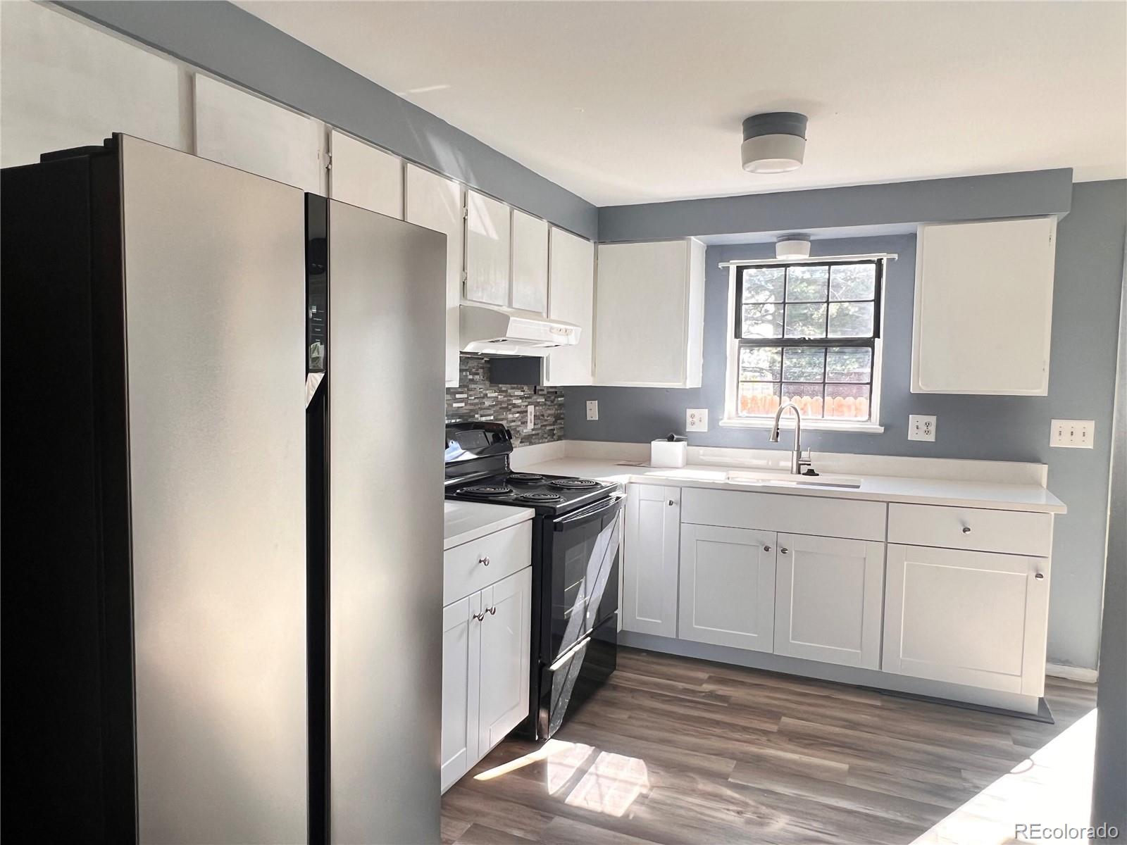 1711 Norfolk Street, Unit D Aurora, CO 80011 - Photo 8 of 16 a kitchen with stainless steel appliances a refrigerator sink and cabinets
