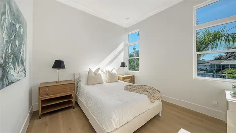 a bedroom with a large bed and a potted plant