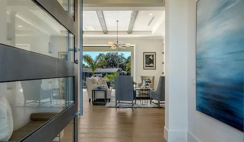 a view of a living room with a floor to ceiling window and wooden floor