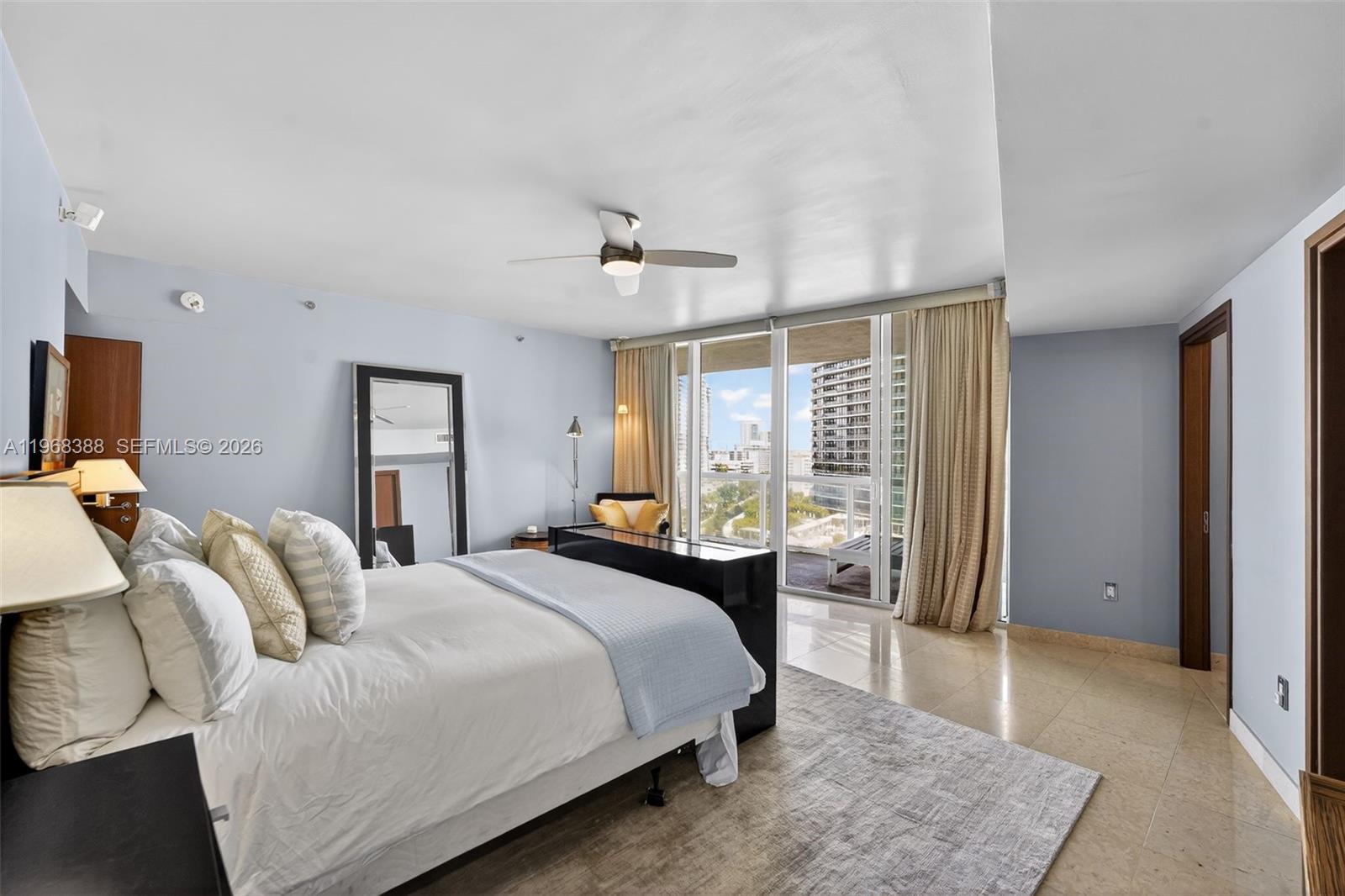 450 Alton Road, Unit 1202 Miami Beach, FL 33139 - Photo 17 of 68 a spacious bedroom with a bed and glass windows