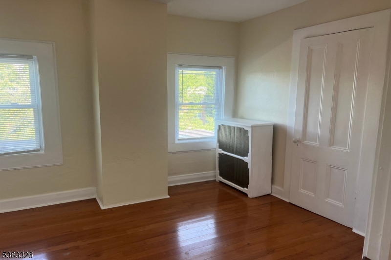 19 Spring Street Bloomfield, NJ 07003 - Photo 16 of 19 an empty room with wooden floor cabinet and windows