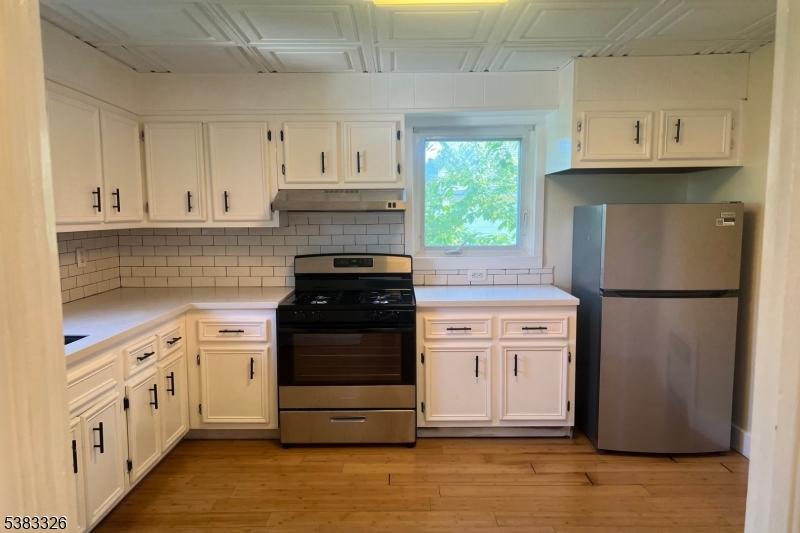 19 Spring Street Bloomfield, NJ 07003 - Photo 9 of 19 a kitchen with white cabinets and refrigerator