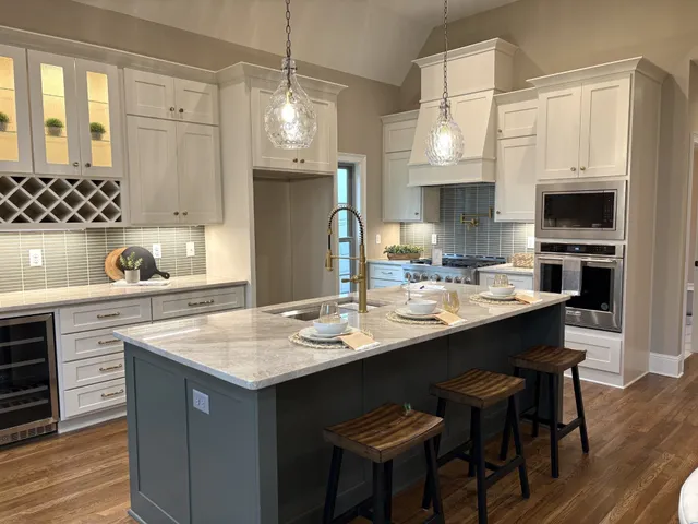 a kitchen with stainless steel appliances granite countertop a sink a stove and a wooden floors