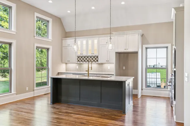 a kitchen with kitchen island granite countertop a sink cabinets and stainless steel appliances